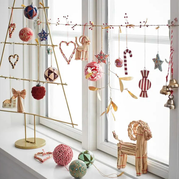 Decorative Christmas tree and ornaments on a windowsill Madam Stoltz