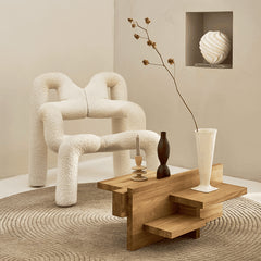 Modern living room with a textured armchair, wooden coffee table, and decorative items.