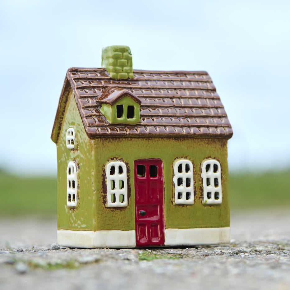Small green model house with a red door 