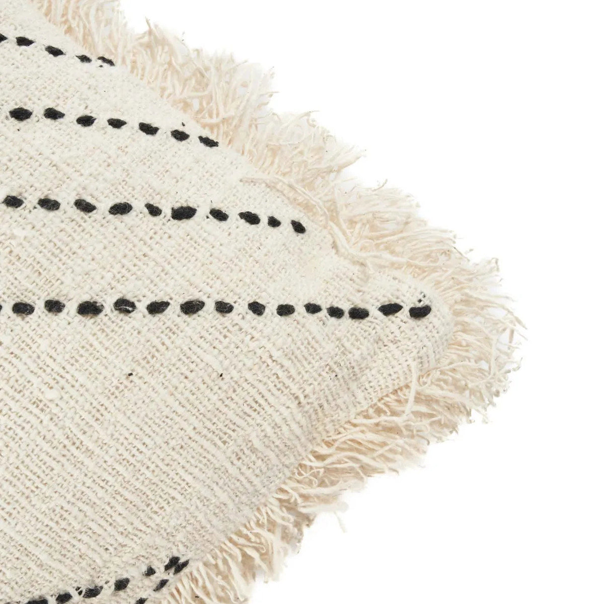 Textured fabric with black dot pattern and frayed edge on a white background