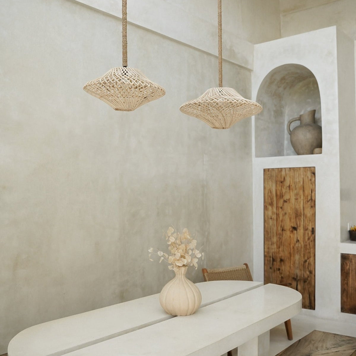 modern interior with a long white table and wooden bench against a neutral wall.