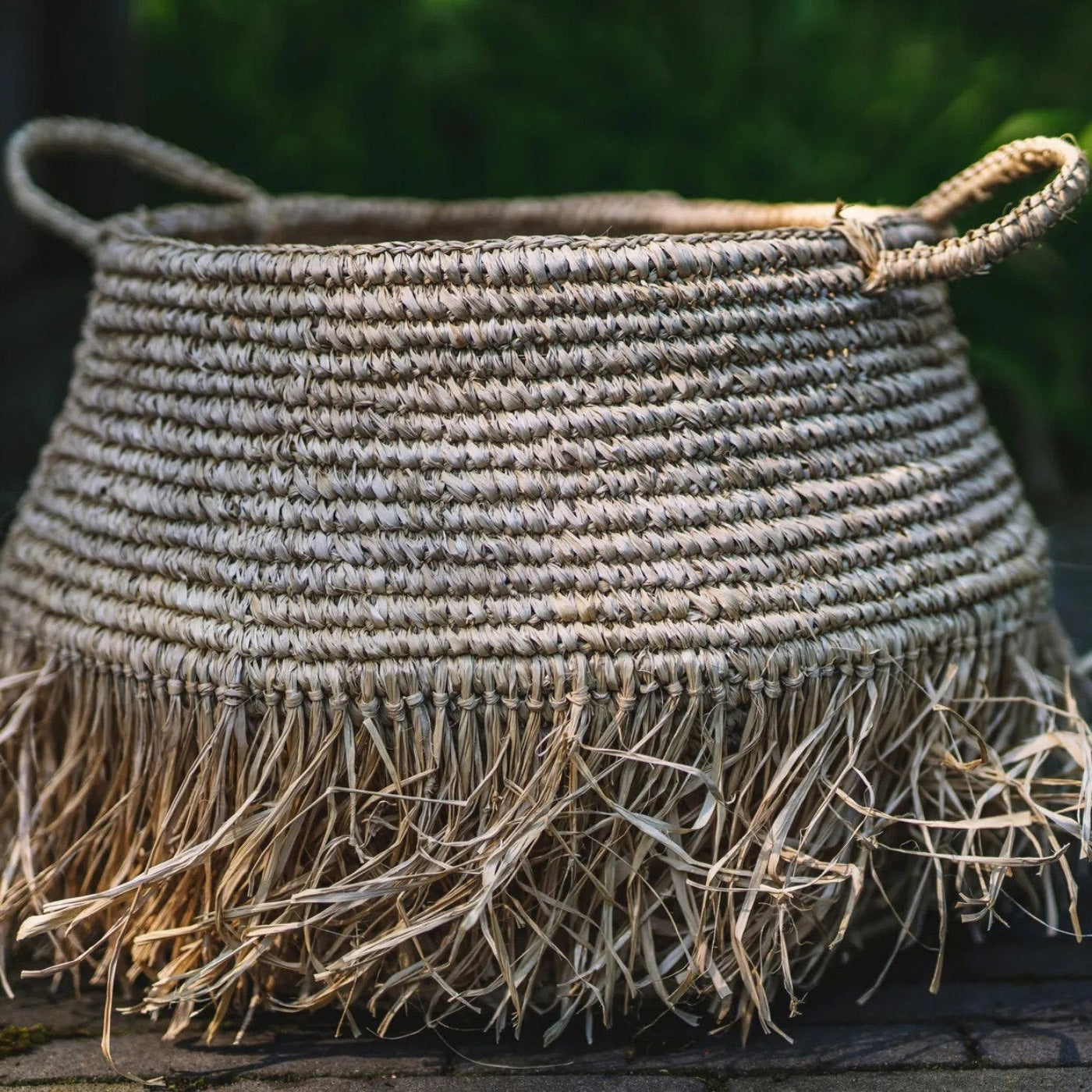 Woven basket with frayed edges on a stone surface