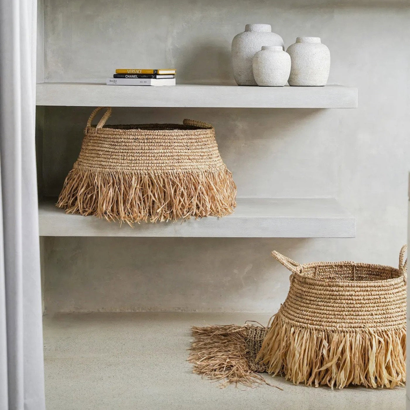 Woven baskets with fringe on a shelf 