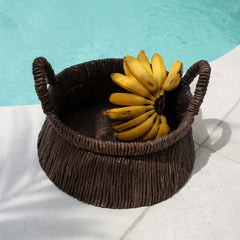 Wicker basket with bananas by a pool