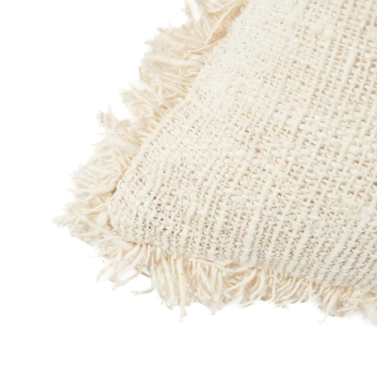 Close-up of a textured beige pillow with fringes