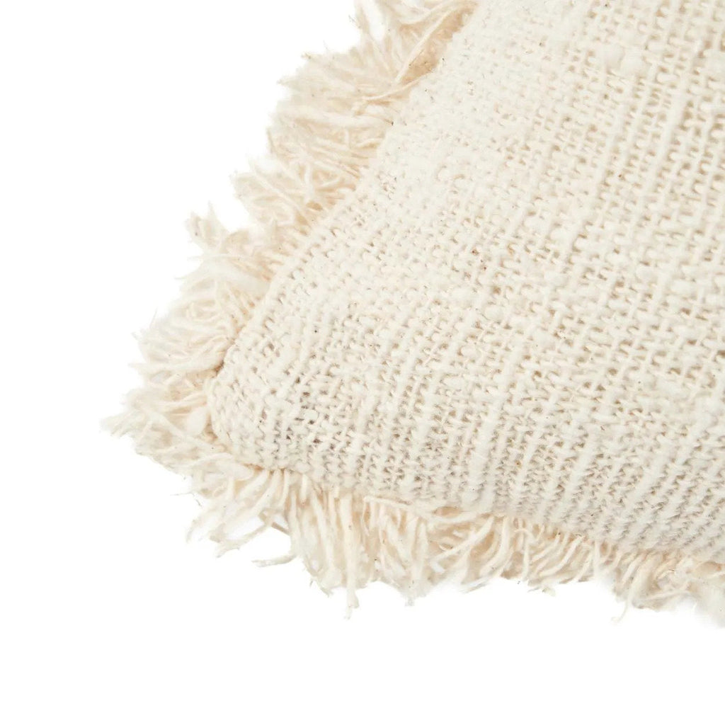 Close-up of a textured beige pillow with fringes