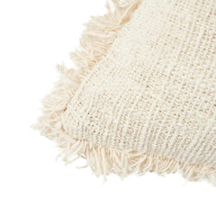Close-up of a textured beige pillow with fringes