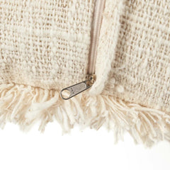 Close-up of a beige textured bag with a zipper and fringes