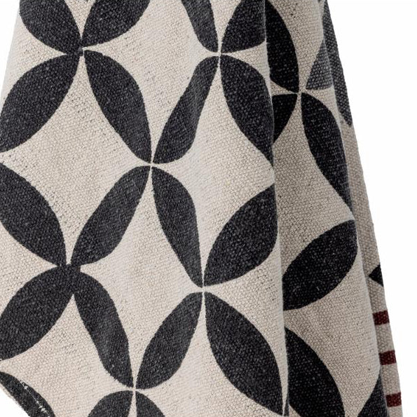 Close-up of a patterned fabric with dark blue and beige design on a white background