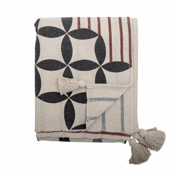 Folded blanket with geometric pattern and tassels on a white background