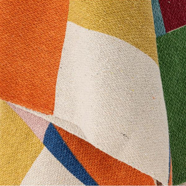 Close-up of a textured rug with geometric pattern in multicolors.