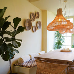 Dining room with wicker chair, rattan lamp, table, Binga basket wall decor