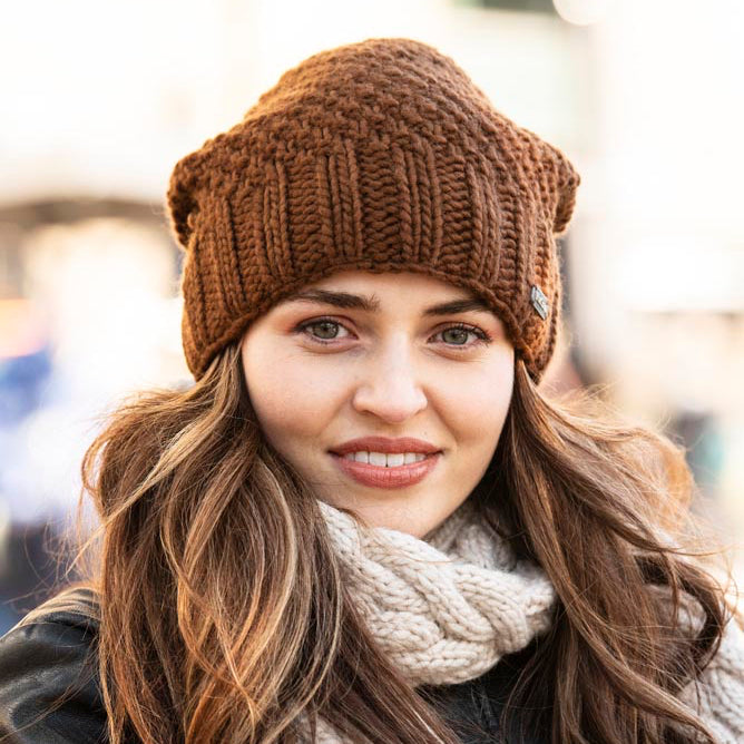 A woman wearing a brown ribbed knit beanie hat by KuSan