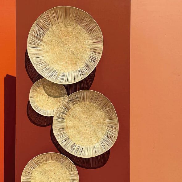 Set of natural decorative plates on a terracotta wall