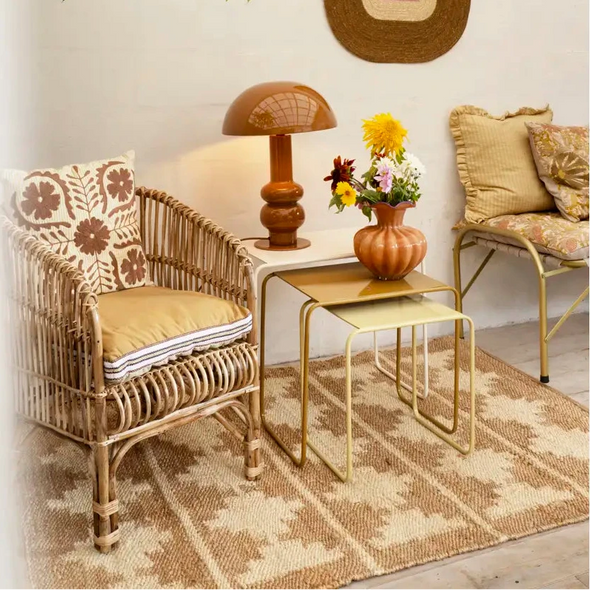 Cozy living room with wicker armchair, gold side table, and brown decoration
