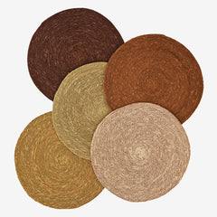 Set of five round woven seagrass placemats in various earthy tones 