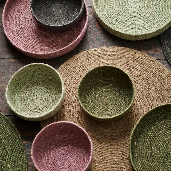 Set of woven seagrass bowls and plates in various colours 