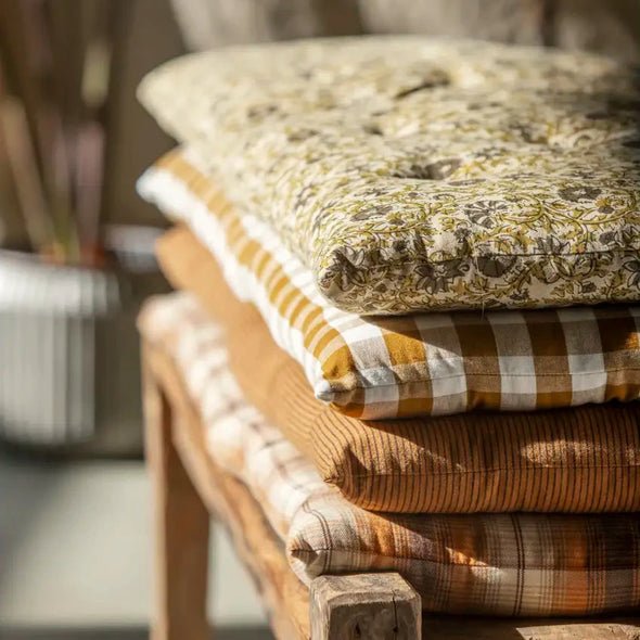Stack of Madam Stoltz printed mattress cushions on a wooden bench
