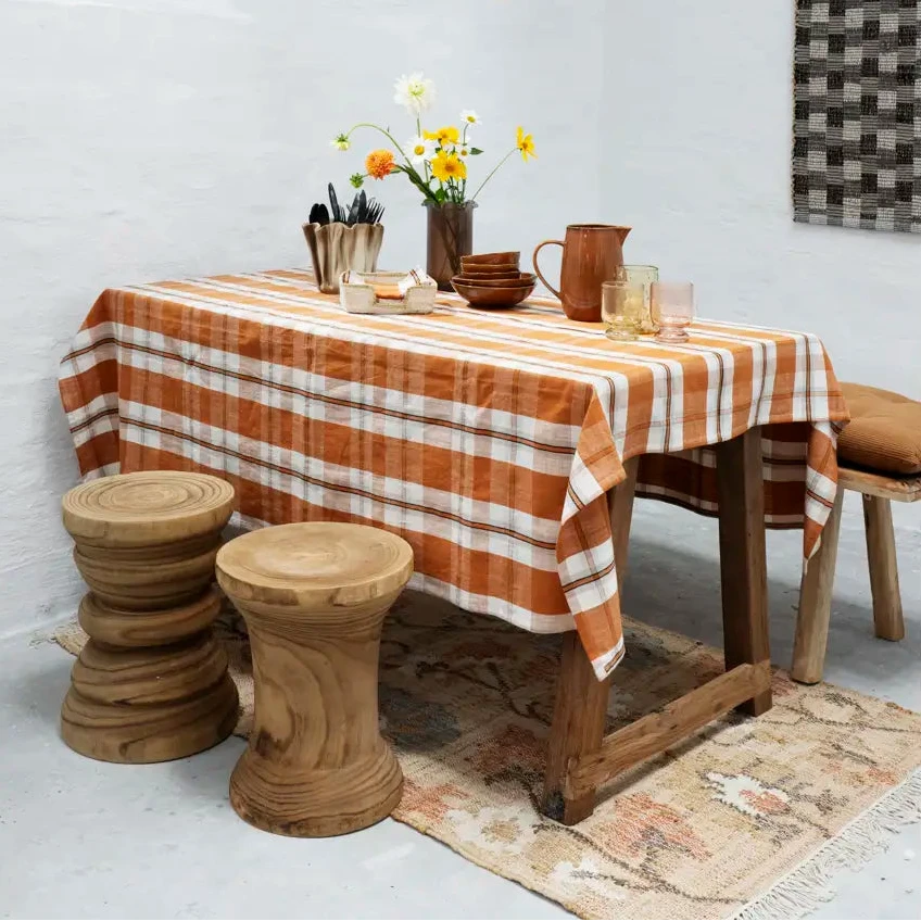 Dining room with wooden table, checkered tablecloth, and decorative elements.