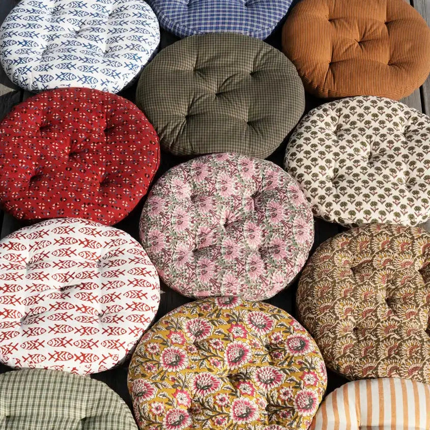 Collection of patterned fabric cushions on a wooden surface
