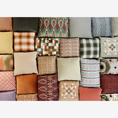 Collection of various patterned cushions arranged in a grid.