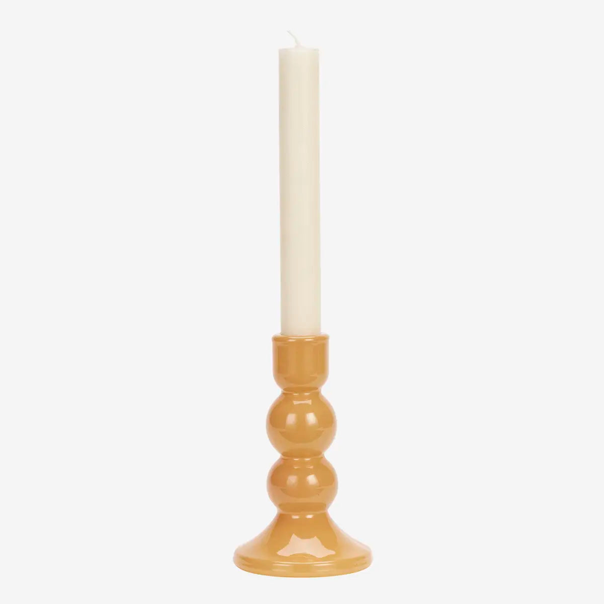 A tall candlestick holder with a glossy pumpkin base and a dinner candle