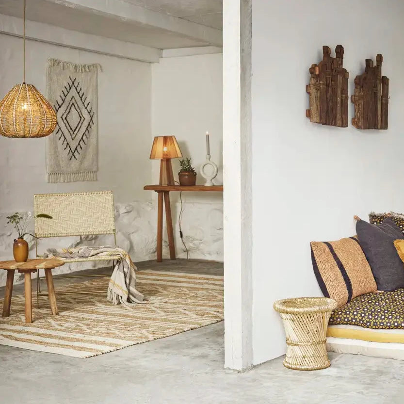 Cosy living room with rustic decor elements such as wicker furniture, woven rug, and wooden wall art.