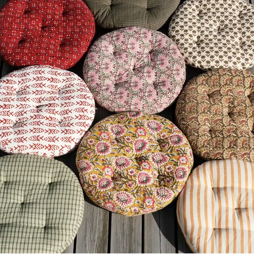 Collection of patterned fabric cushions on a wooden surface