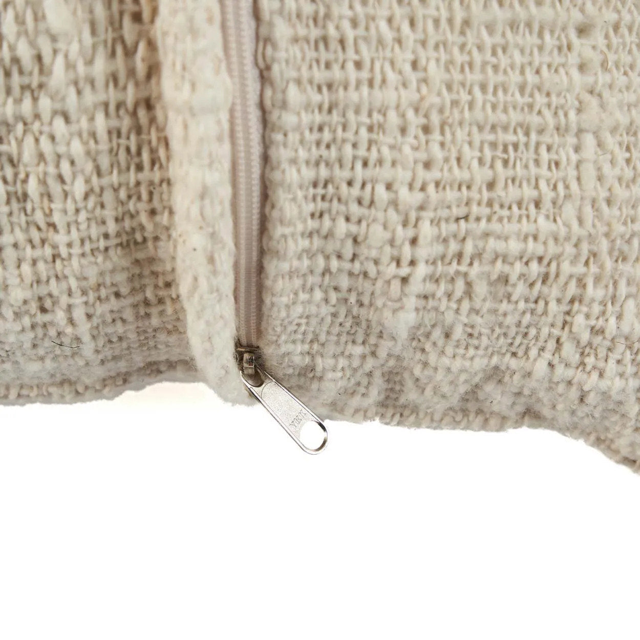Close-up of a textured boho cushion with a zipper on a white background