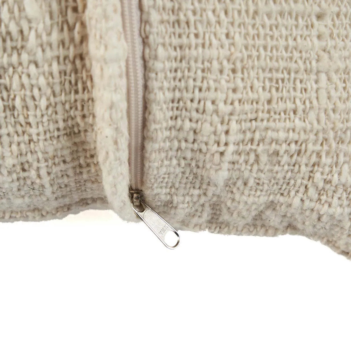 Close-up of a textured boho cushion with a zipper on a white background