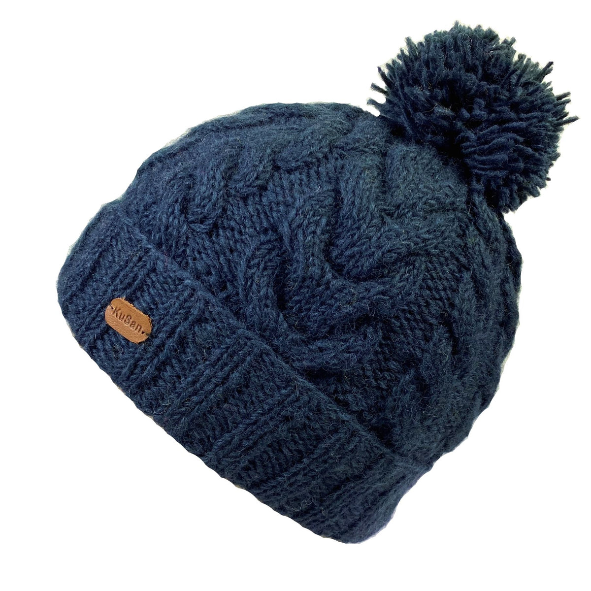 A navy blue cable-knit beanie with a matching pom-pom on top and a small brown leather KuSan brand tab