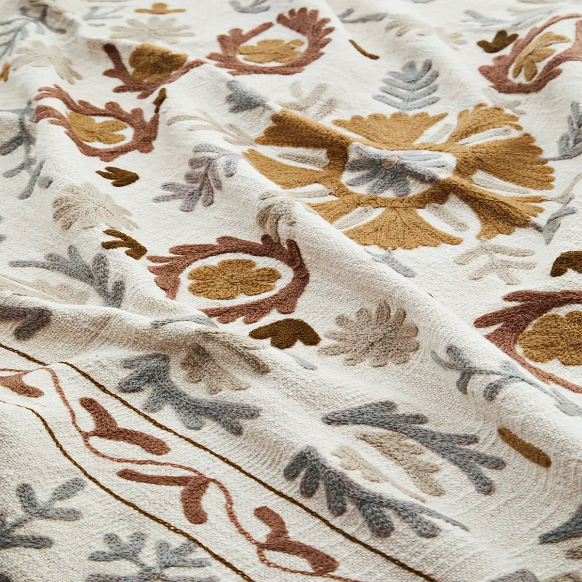 Suzani throw blanket off white brown embroidery close up