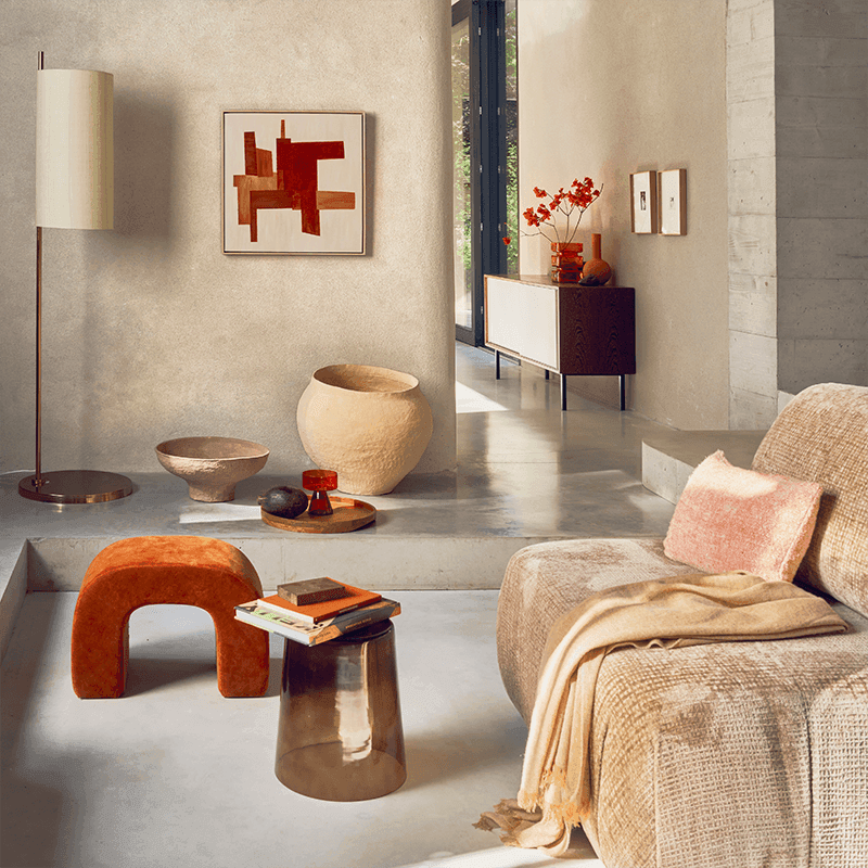 Modern living room with a textured wall, decorative items, and a sofa.