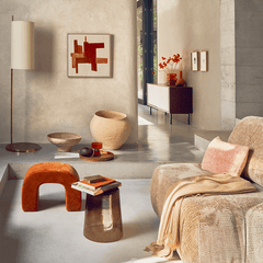 Modern living room with a textured wall, decorative items, and a sofa.