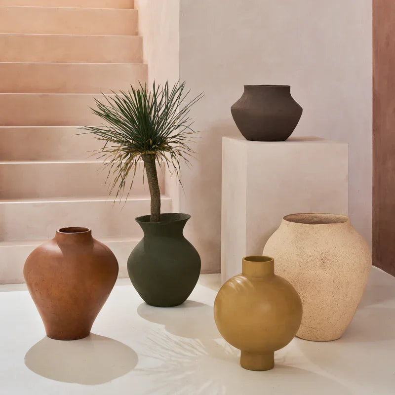 Collection of various ceramic vases on a light surface