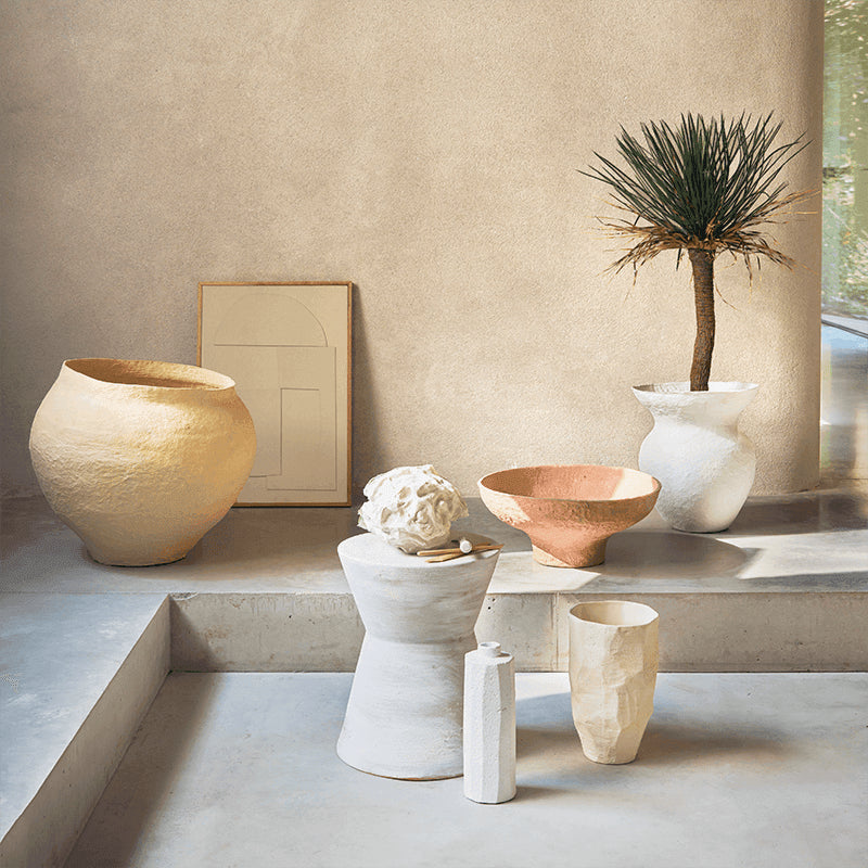 Decorative vases and sculptures on a concrete surface light colours