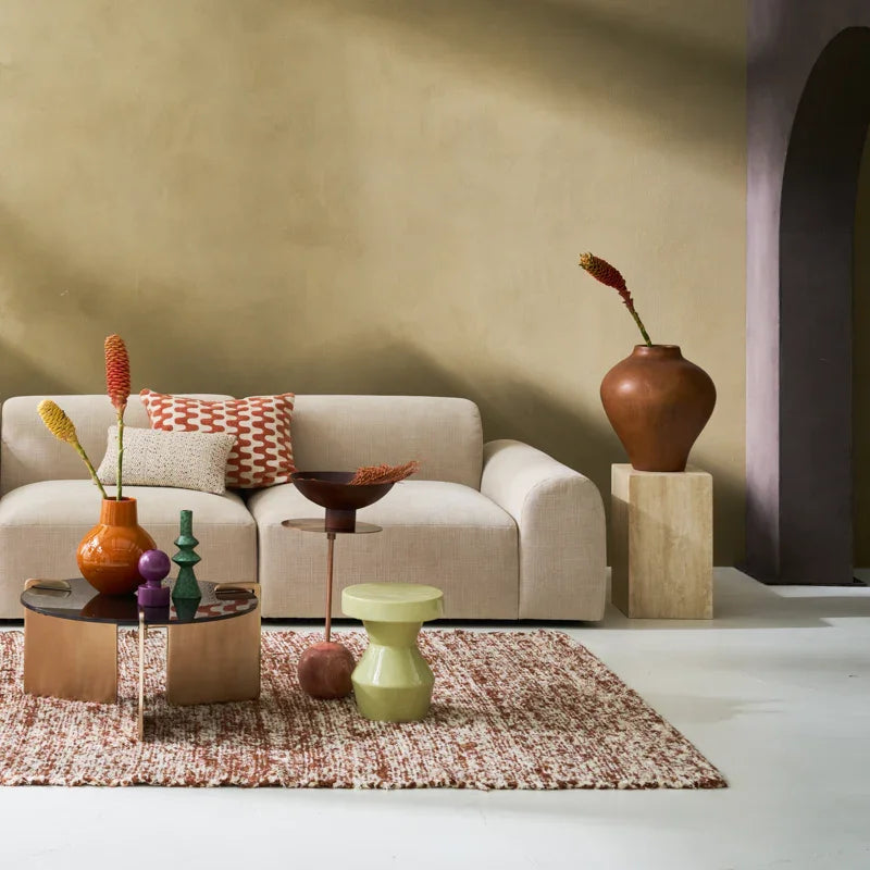 Modern living room with a beige sofa, decorative vases, and a coffee table.