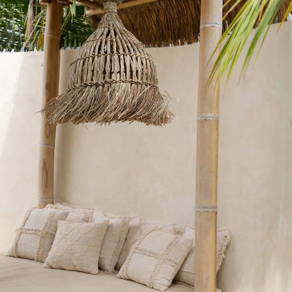 Nestled outdoor seating area with woven pendant light and textured cushions.