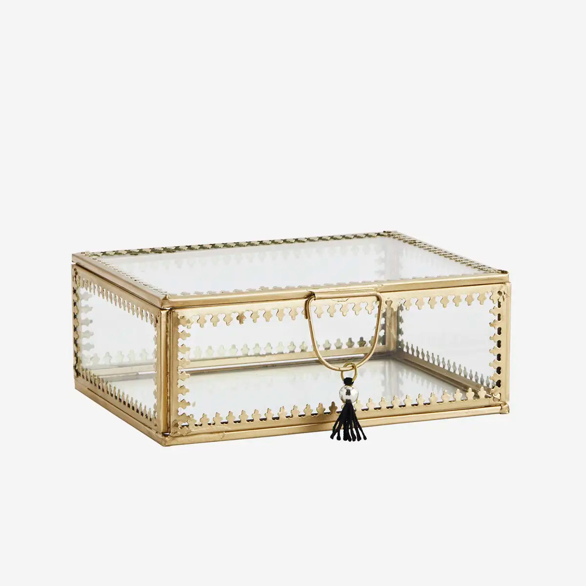 A rectangular glass jewelry box with a gold metal frame, decorative beaded borders, a top handle, and a black tassel accent