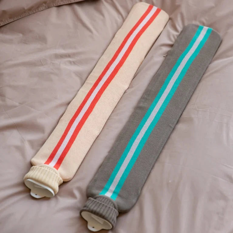 Two striped hot water bottles on a bed