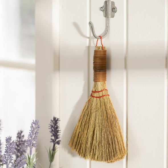 seagrass broom hanging on a hook 