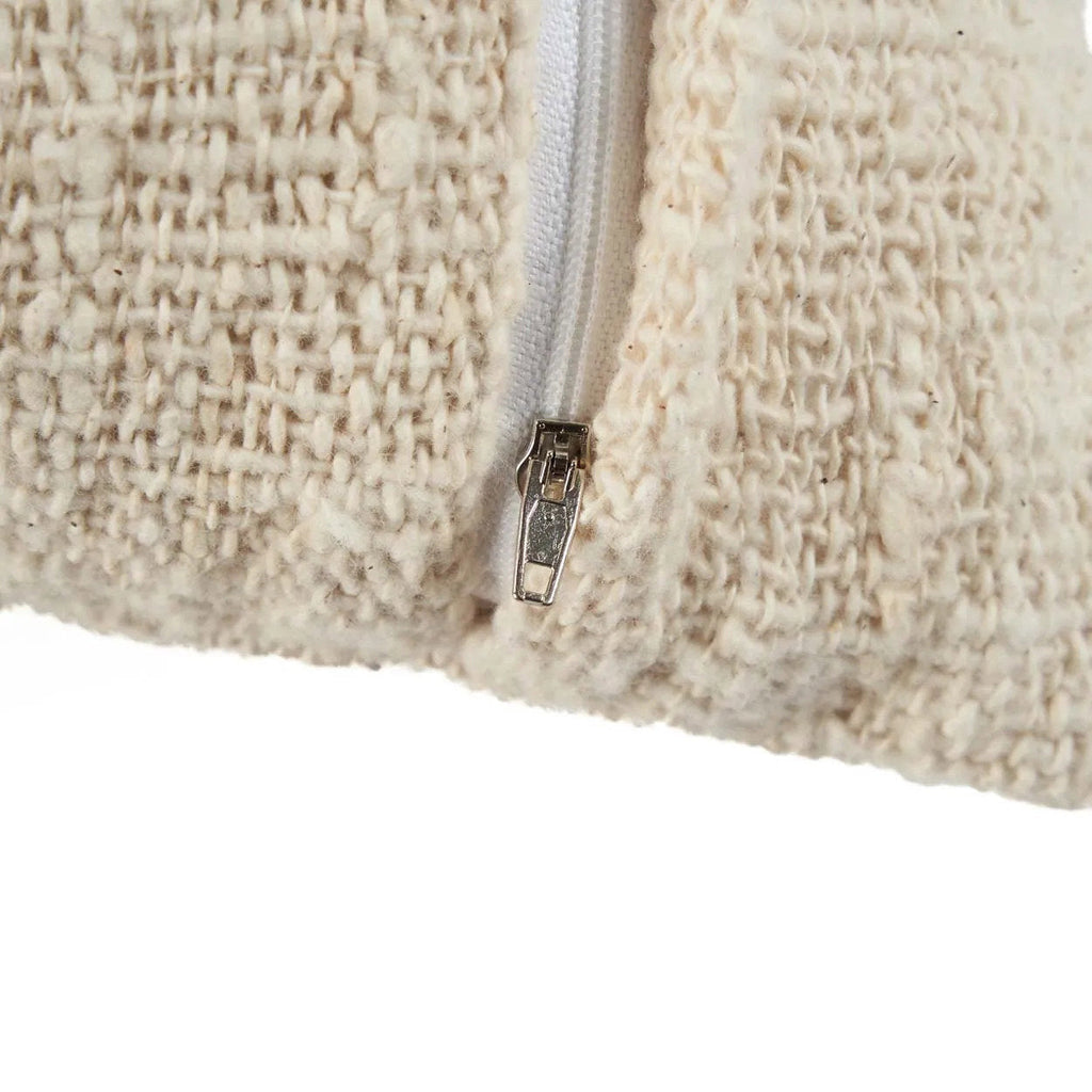 Close-up of a textured beige cushion with a zipper