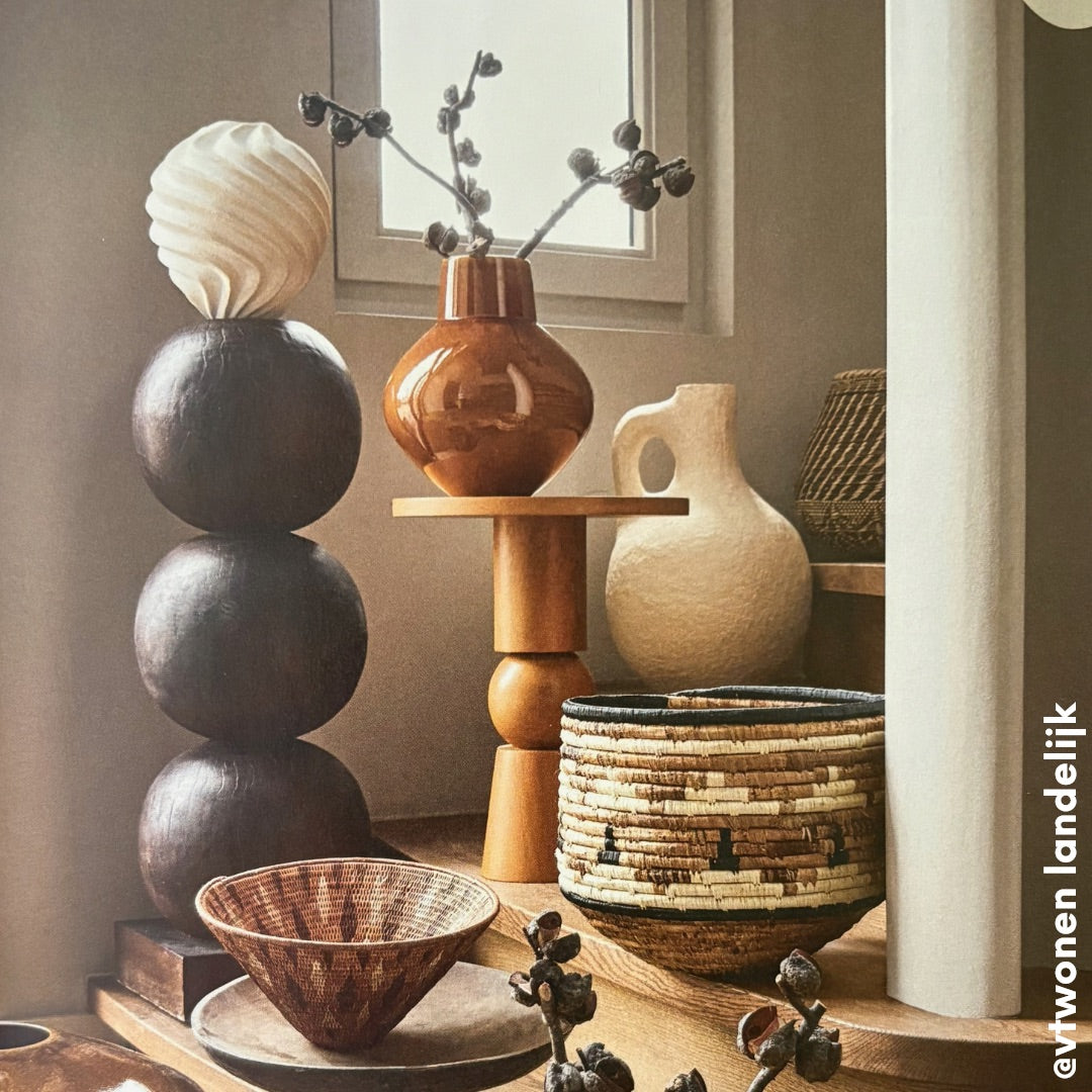 Decorative vases and bowls on a wooden pedestal burst