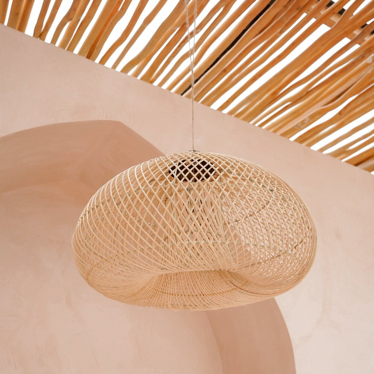 Woven rattan pendant light hanging from a wooden ceiling
