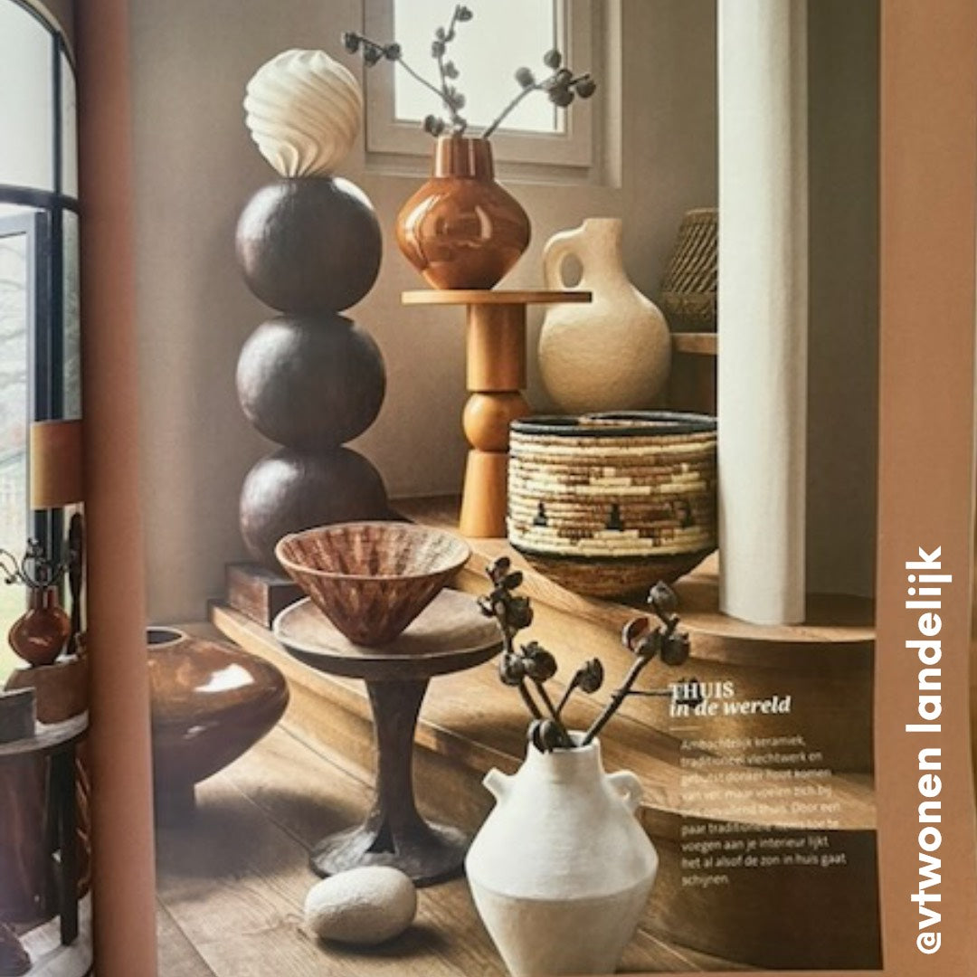 Decorative home interior with various ceramic vases and bowls on a wooden surface.