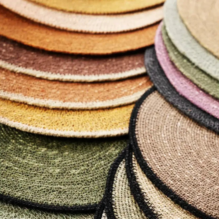 Stack of round woven placemats in various colours by Madam Stoltz
